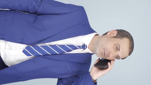 Man in Blue Suit Talking on Phone