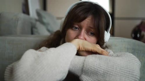 Sad Woman with Headphones Looking Down