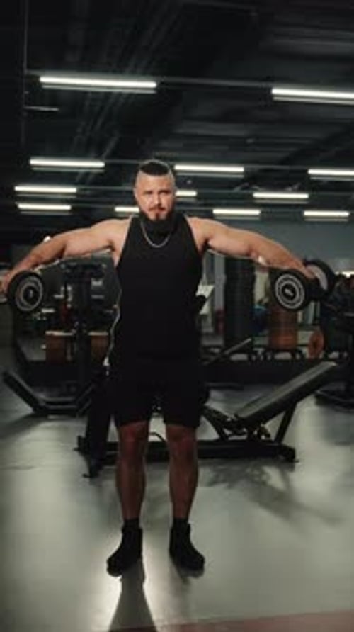 Powerful Sportsman Lifting Dumbbells for Lateral Raise Exercise Strengthening Shoulder Muscles