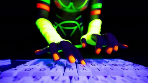 Woman Typing on Fluorescent Keyboard Under Blacklight