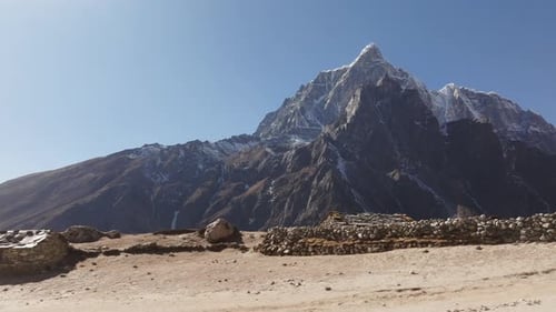 Drohnenaufnahme eines abgelegenen nepalesischen Dorfes im Himalaya mit traditionellen Häusern und hohen Türmen