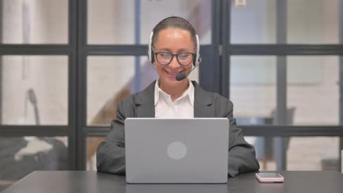 Mixed Race Business Woman with Headset Talking Online with Customer in Call Center