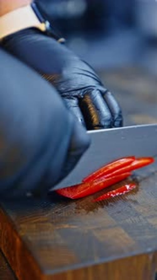 Chef Slices Red Pepper on Cutting Board