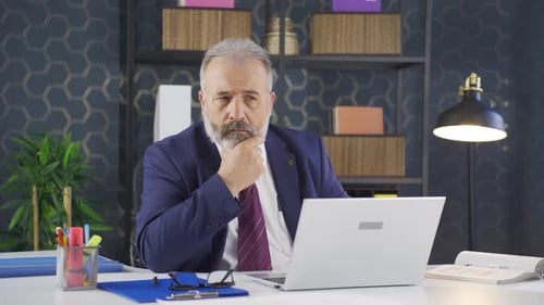 Thinking businessman looking at camera.