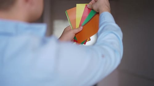Close Up of Person Holding Colorful Paper Swatches