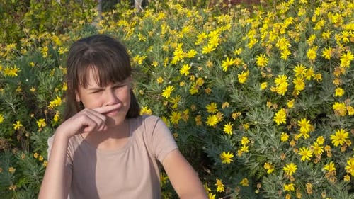 Young Girl with Allergies Rubbing Nose by Flowers
