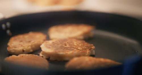 A Cook Collects Baked Pancakes With Apples From the Pan