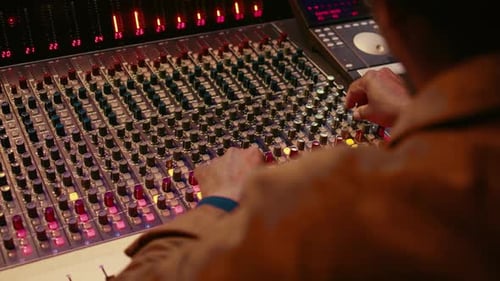 Audio Engineer Working with Mixing Console in Studio