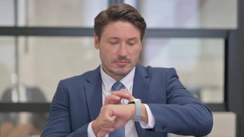 Man Interacting With Smartwatch at Work