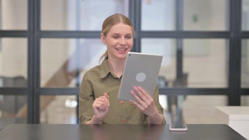 Mature Adult Woman Doing Video Chat on Tablet in Office
