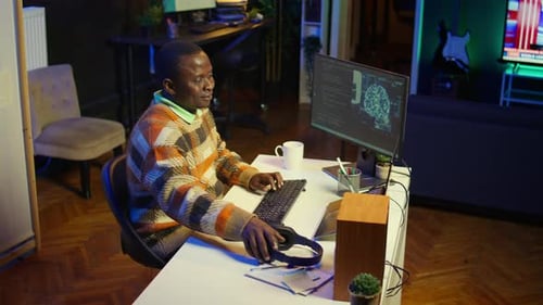 Homem afro-americano trabalhando no computador para escrever código e programação