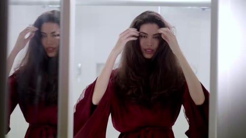 Woman Styling Her Hair in the Mirror