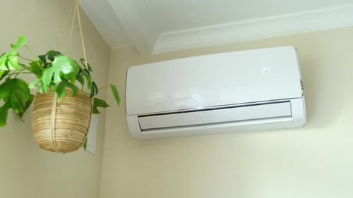 The process of turning on the air conditioner in the home living room, close-up