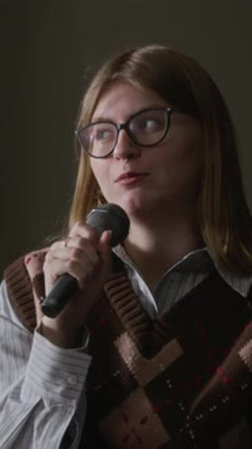 Young woman speaking into a microphone indoors