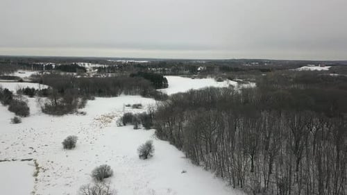 Drone flying over snow covered winter woodland scene Minnesota