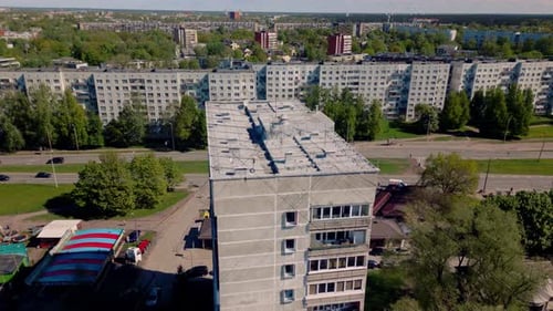 Fixed aerial Soviet apartment building blocks and street with traffic passing by