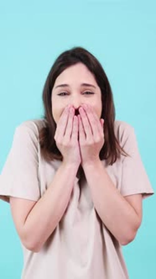 Young Woman Expressing Happiness and Excitement on Turquoise Background