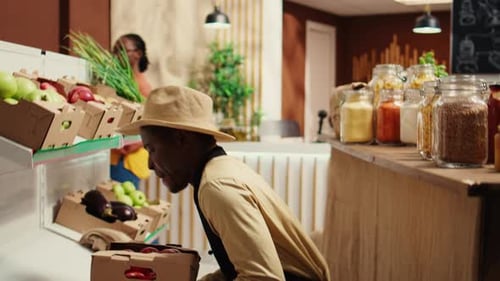 Market Worker Stocking Fruits and Vegetables on Shelves
