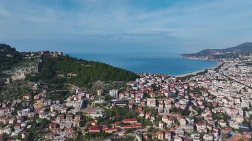 Aerial Video of a Coastal City With the Azure Sea in the Background and Lush Green Parks Seen From