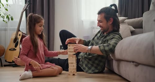 A Lonely Father a Brunette Man in a Green Checkered Shirt Plays with His Little Daughter a Brunette