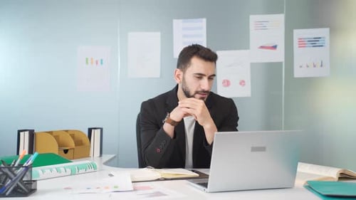 Man Video Conferencing From Office Desk