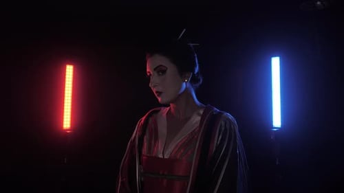 Japanerin dreht sich im traditionellen Geisha-Kostüm mit Neonlichtern um