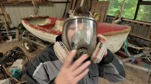 Worker putting on full face respirator mask for workshop safety