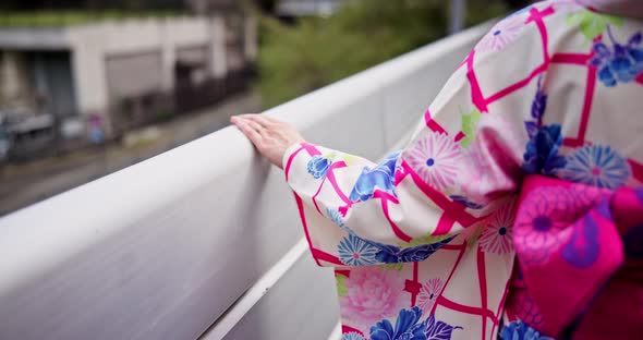 Hand, kimono and railing with person walking on bridge in Japan for ...