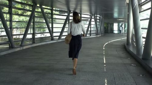 Businesswoman Walking Through Tunnel in City 30s