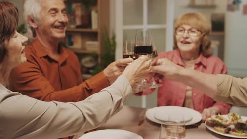 Des retraités joyeux fêtent leur anniversaire et tintent des lunettes