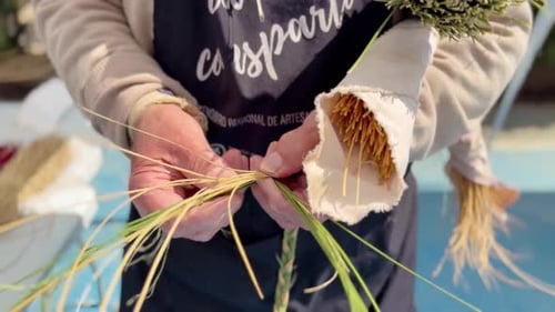 Close up of elderly farmer hands weaving esparto grass braid. Traditional craft, rural lifestyle,