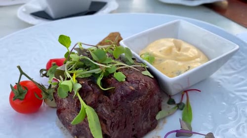 Juicy fillet steak with bearnaise sauce, salad and french fries at a restaurant table with food, big