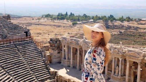 Stunning video of a young white caucasian ginger girl standing at the Roman amphitheater at the ruin