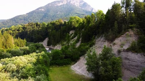 Panoramic aerial view of a forested mountain landscape with a river next to it