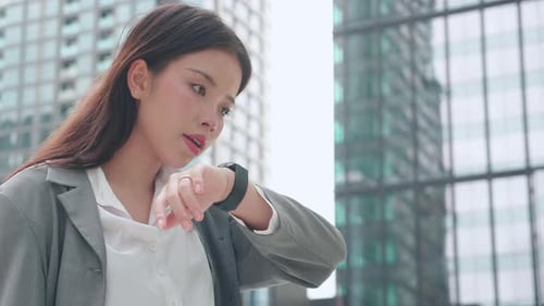 Young Woman Using Smartwatch in City Business Environment