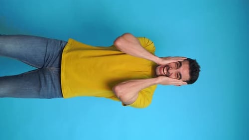 Excited Young Man with Hands on Cheeks in Studio