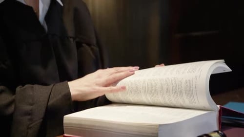 Judge Consults Law Book in Courtroom Close Up