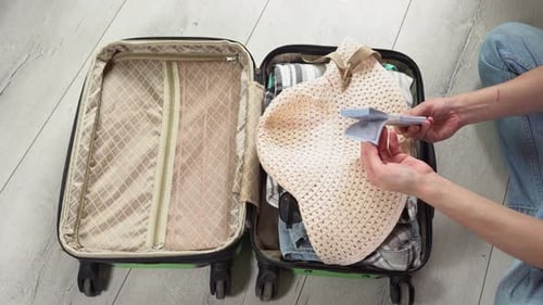 Man packing his suitcase for long journey with wad of money. Guy closes the green baggage case