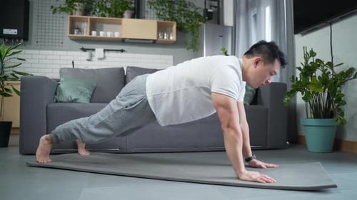 Man Exercising in Apartment Doing Plank