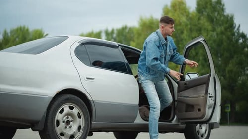 White Male Leaving Car Youth in Denim Moves Through Quiet Suburban Parking Area Young Man in Ripped