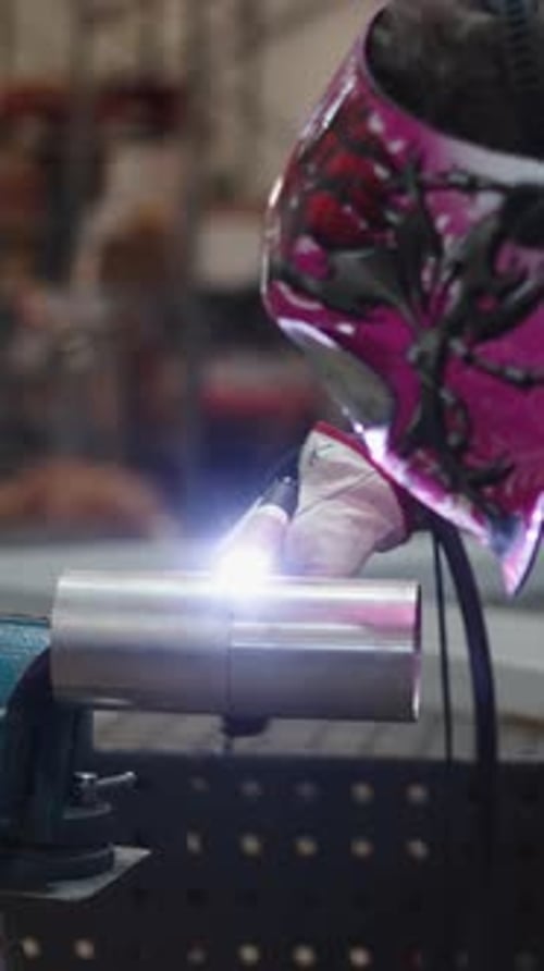 Welder Works on Metal Pipes in Industrial Setting