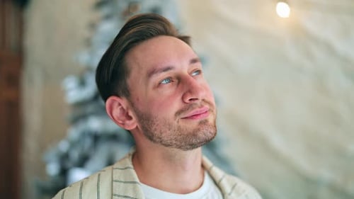 Man Looks Upward with Hopeful Expression in Home