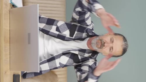 Man Leans Back, Taking a Break from Laptop