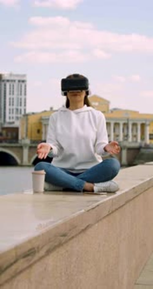 Young Woman Meditating in Vr Glasses in the Midst of a Bustling City Vertical Video