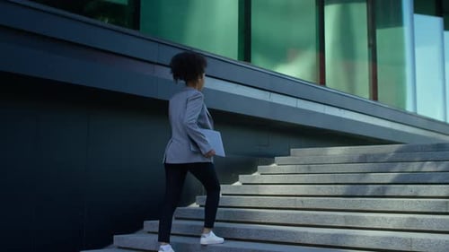 Businesswoman Walking Up Office Steps Outdoors
