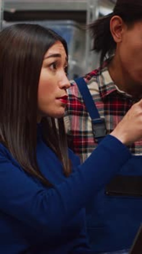 Young Adults Working on Laptop in Warehouse