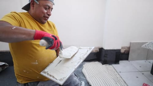 Man Applying Adhesive to Tile for Home Improvement