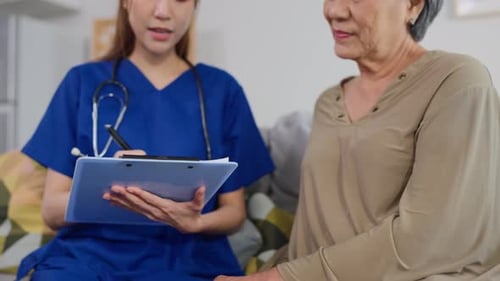Asian beautiful caregiver examine senior woman patient at nursing home.