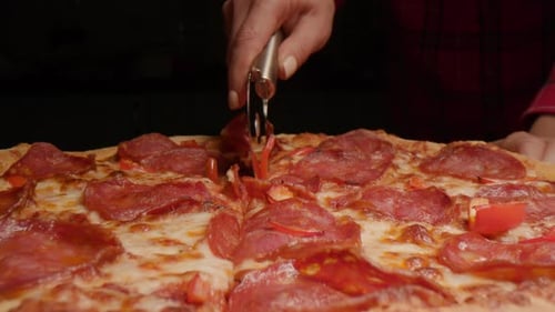 Slicing Fresh Pepperoni Pizza with Pizza Cutter