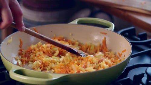 Chopped Vegetables Cooking in Skillet Stirred with Spoon